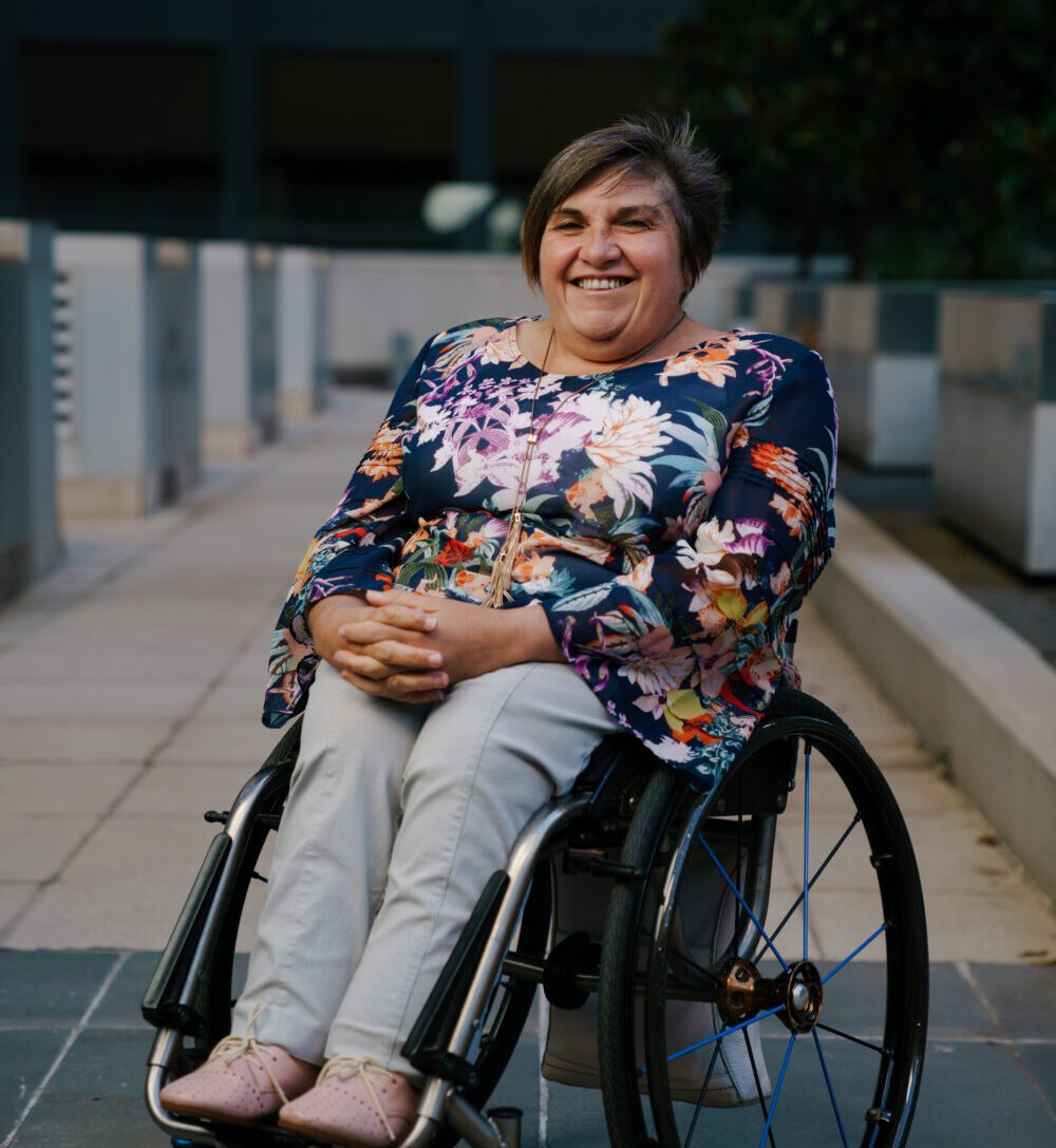 Lisa Chaffey sitting in her wheelchair and smiling at the graduation of Williamson